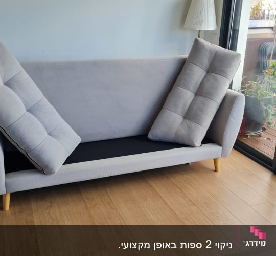 ספת בד אפורה לאחר ניקוי בסלון ביתי עם כריות מורמות לייבוש